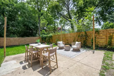 a patio with a table and chairs and a fence at Woodburn Villa by Blackhouse in Cincinnati