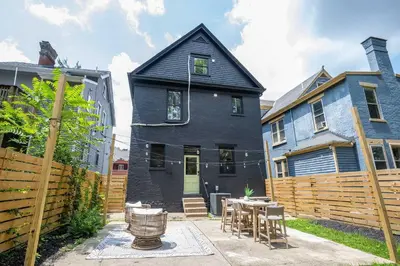a black house with a wooden fence and a table at Woodburn Villa by Blackhouse in Cincinnati