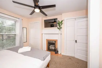 a bedroom with a fireplace and a ceiling fan at Clintonville Charm in Columbus