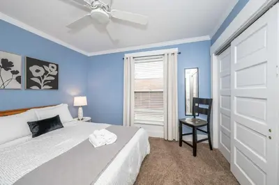 a bedroom with blue walls and a bed with a ceiling fan at Clintonville Charm in Columbus