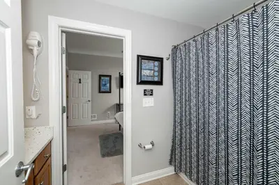 a bathroom with a shower with a blue and white shower curtain at Mason Oasis 5 BDR Home Sweet Home Family-Friendly in Mason