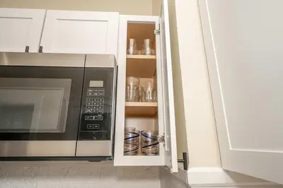 a kitchen with a microwave in a white cabinet at The Cincinnati Cottage in Cincinnati