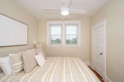a bedroom with a bed with pillows and a window at The Cincinnati Cottage in Cincinnati