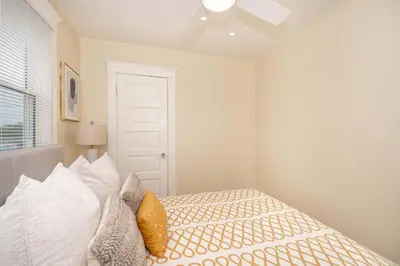 a white bedroom with a bed with pillows at The Cincinnati Cottage in Cincinnati