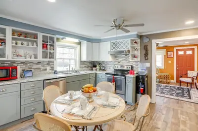 a kitchen with a table with a bowl of fruit on it at 1 Block to Beach Home with Hot Tub in Port Clinton! in Port Clinton