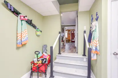 a hallway with stairs and skis on the wall at 1 Block to Beach Home with Hot Tub in Port Clinton! in Port Clinton