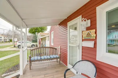 a porch with a bench on the side of a house at 1 Block to Beach Home with Hot Tub in Port Clinton! in Port Clinton