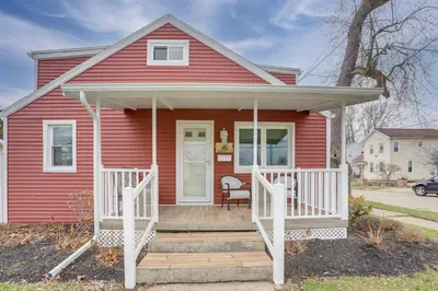 a red house with a wooden porch and a white door at 1 Block to Beach Home with Hot Tub in Port Clinton! in Port Clinton