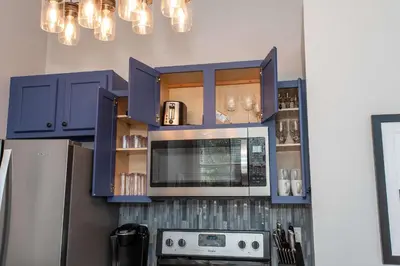 a kitchen with blue cabinets and a microwave at Heart of Mainstrasse 1 in Covington