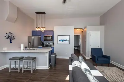 a living room with a couch and a kitchen at Heart of Mainstrasse 1 in Covington