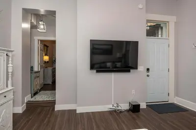 a living room with a flat screen tv on a wall at Heart of Mainstrasse 2 in Covington