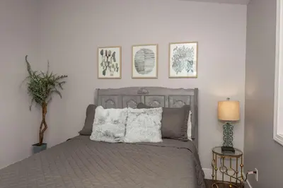 a bedroom with a gray bed with three pictures on the wall at Heart of Mainstrasse 2 in Covington