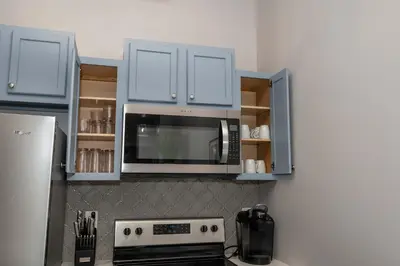 a kitchen with blue cabinets and a microwave at Heart of Mainstrasse 2 in Covington