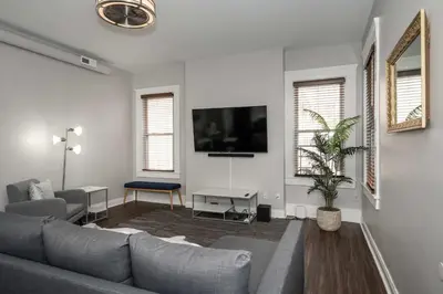 a living room with a couch and a tv at Heart of Mainstrasse 3 in Covington