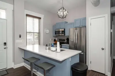 a kitchen with blue cabinets and a sink and a refrigerator at Heart of Mainstrasse 3 in Covington