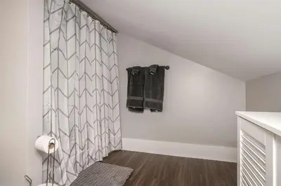 a bathroom with white walls and a shower curtain at Heart of Mainstrasse 4 in Covington