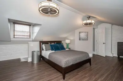 a bedroom with a bed with blue pillows at Heart of Mainstrasse 4 in Covington