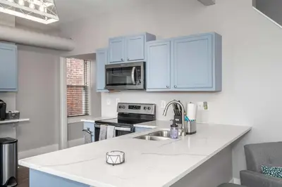 a kitchen with white cabinets and a counter top at Heart of Mainstrasse 4 in Covington