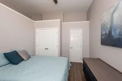 a bedroom with a bed and a painting on the wall at Heart of Mainstrasse Suites in Covington