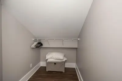 a small room with a bed and a shelf at Heart of Mainstrasse Suites in Covington
