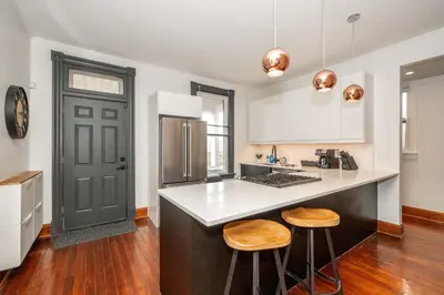 a kitchen with a counter and two stools at Historic Retreat Gateway in Dayton