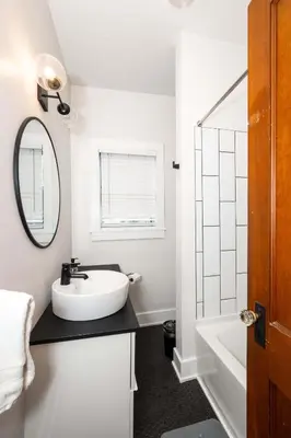 a white bathroom with a sink and a mirror at Historic Retreat Gateway in Dayton