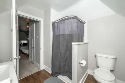 a bathroom with a shower curtain and a toilet at Historic Retreat Gateway in Dayton
