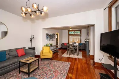 a living room with a couch and a tv at Historic Retreat Gateway in Dayton