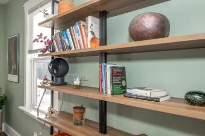a room with wooden shelves with books and a window at Northside Nook Home for 6 in Cincinnati
