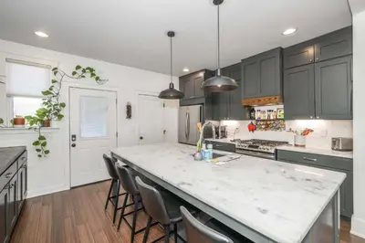 a kitchen with black cabinets and a white counter top at Northside Nook Home for 6 in Cincinnati