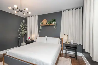 a bedroom with a white bed and a black wall at Northside Nook Home for 6 in Cincinnati