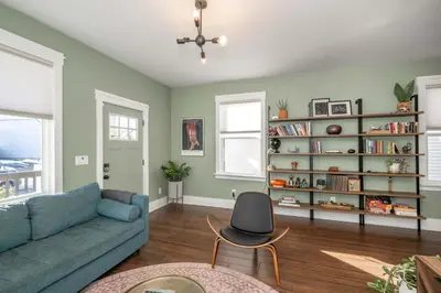 a living room with a blue couch and a book shelf at Northside Nook Home for 6 in Cincinnati