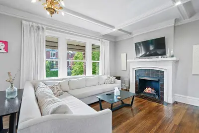 a living room with a white couch and a fireplace at Urban Elegance Getaway in Columbus
