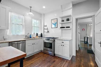 a kitchen with white appliances and a wooden floor at Urban Elegance Getaway in Columbus