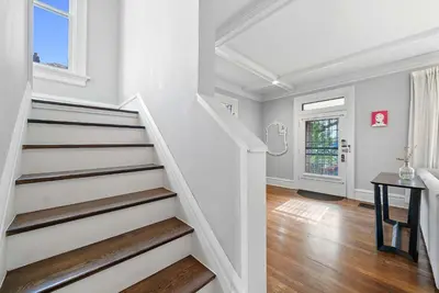 a staircase in a home with white walls and wood floors at Urban Elegance Getaway in Columbus