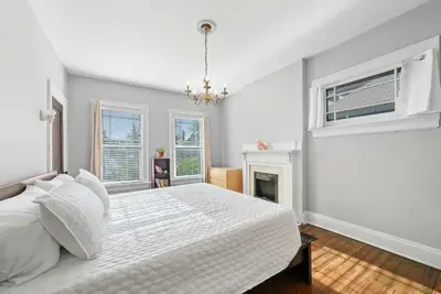 a white bedroom with a bed and a fireplace at Urban Elegance Getaway in Columbus