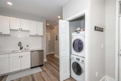 a white kitchen with a washer and dryer in it at The LUXE Spot 1 in Covington