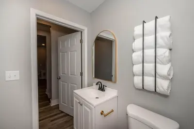 a white bathroom with a sink and a mirror at LUXE Spot 2 in Covington
