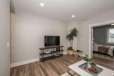 a living room with a flat screen tv and a bed at LUXE Spot Suites in Covington