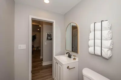 a white bathroom with a sink and a mirror at LUXE Spot Suites in Covington