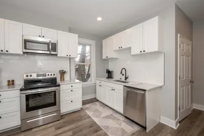 a kitchen with white cabinets and stainless steel appliances at LUXE Spot Suites in Covington