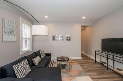 a living room with a couch and a flat screen tv at LUXE Spot Suites in Covington