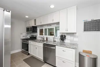 a kitchen with white cabinets and stainless steel appliances at Hunley Haven Retreat in Cincinnati