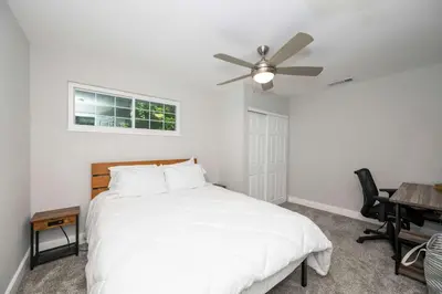 a bedroom with a white bed and a ceiling fan at Hunley Haven Retreat in Cincinnati