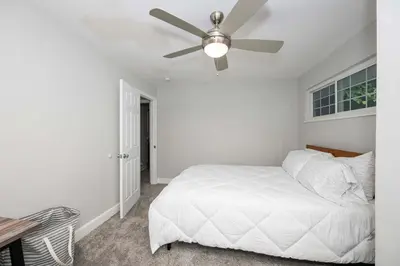 a bedroom with a white bed and a ceiling fan at Hunley Haven Retreat in Cincinnati