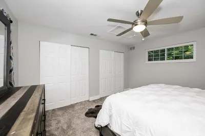 a bedroom with white walls and a ceiling fan at Hunley Haven Retreat in Cincinnati