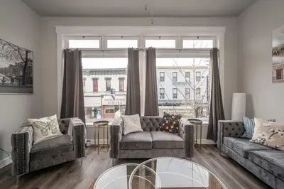 a living room with two couches and a large window at Heart of Madison 2 in Covington