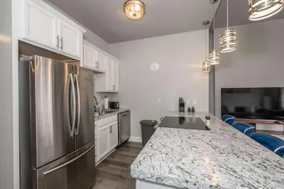 a kitchen with a stainless steel refrigerator and white cabinets at Heart of Madison 2 in Covington