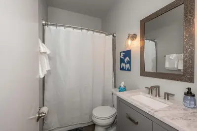 a bathroom with a toilet and a sink and a mirror at Heart of Madison 2 in Covington