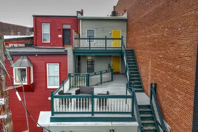 a house with a staircase next to a brick wall at Heart of Madison 2 in Covington